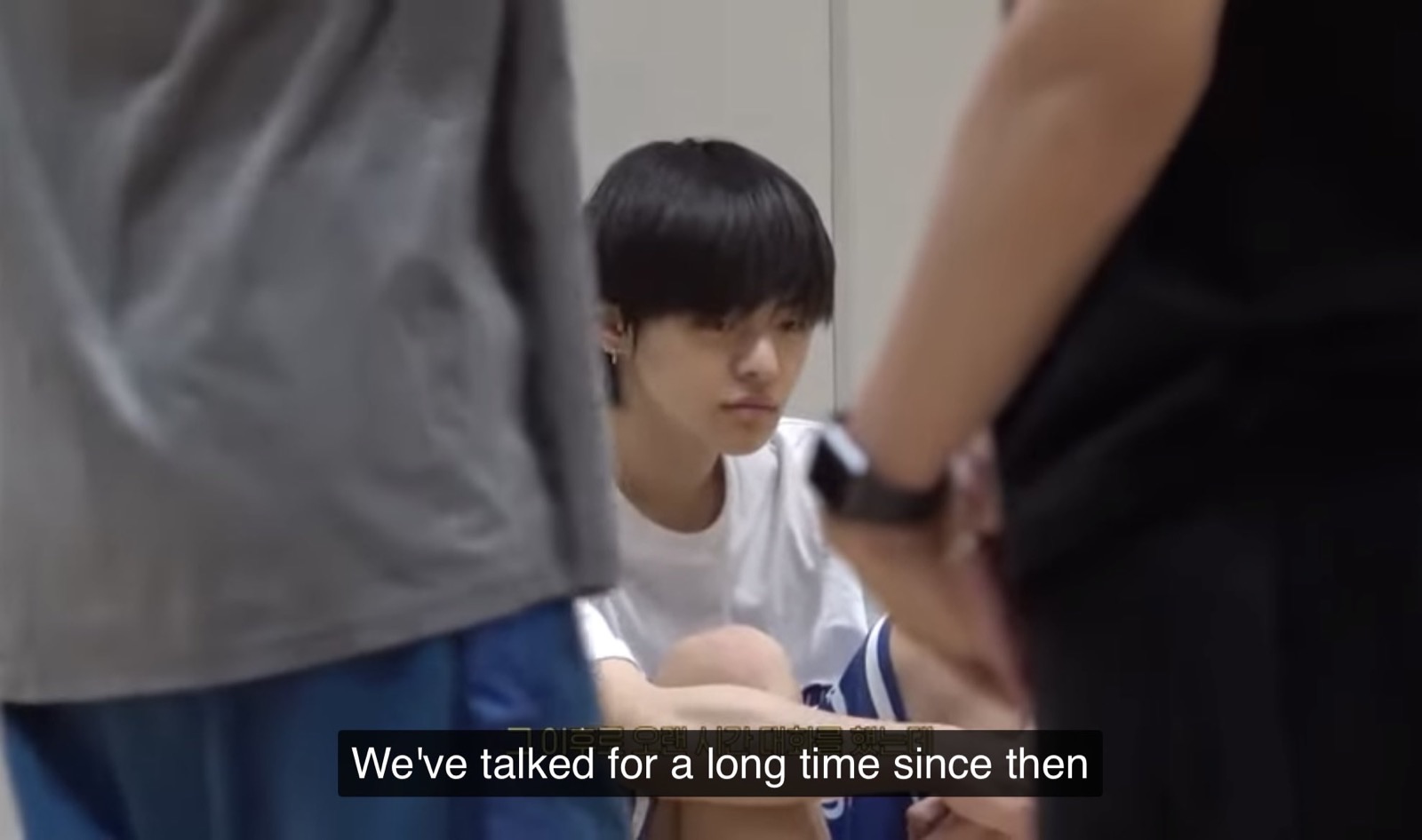 Leo sitting on the practice room floor while staff talk to him